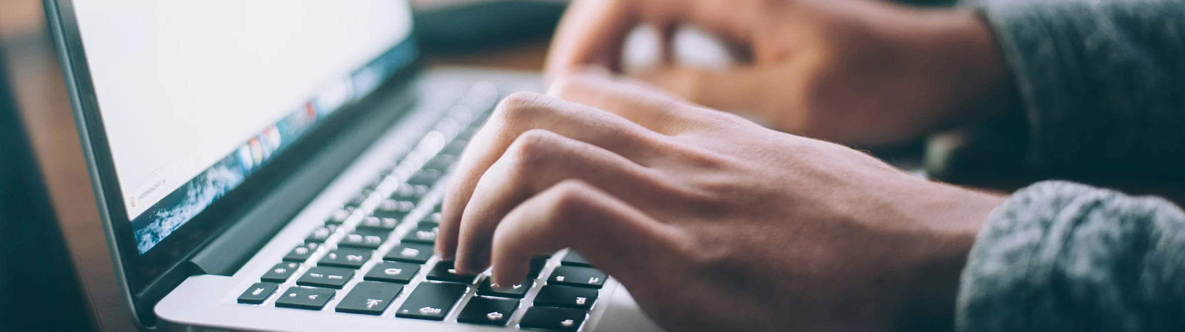 Person's hands using a laptop keyboard